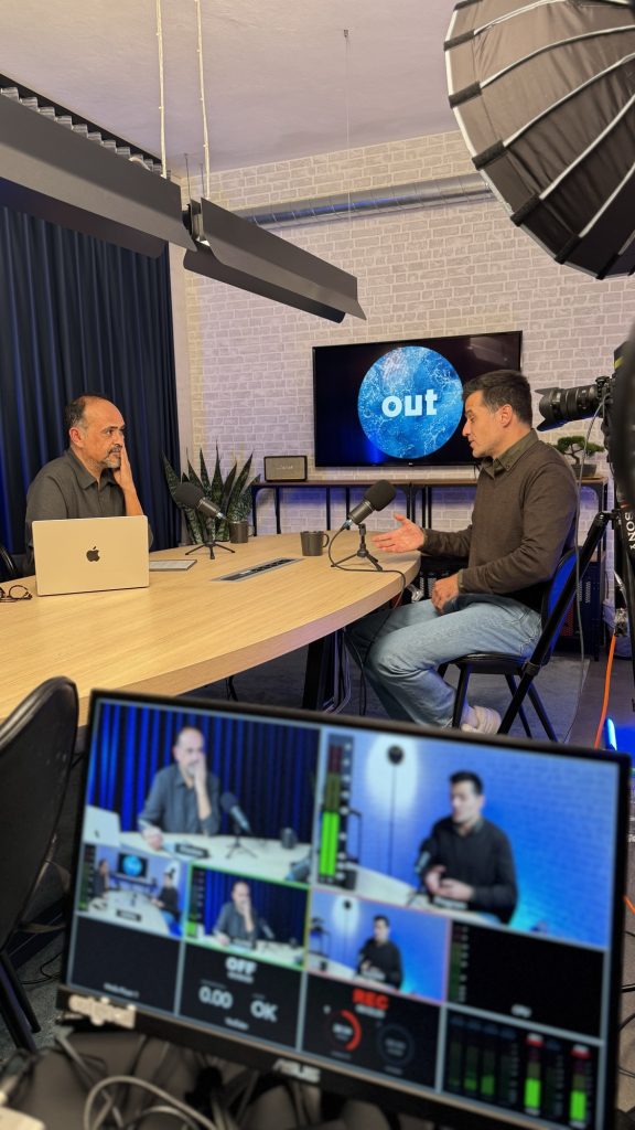 Apresentador de podcast ao microfone no estúdio Outglocal em Aveiro