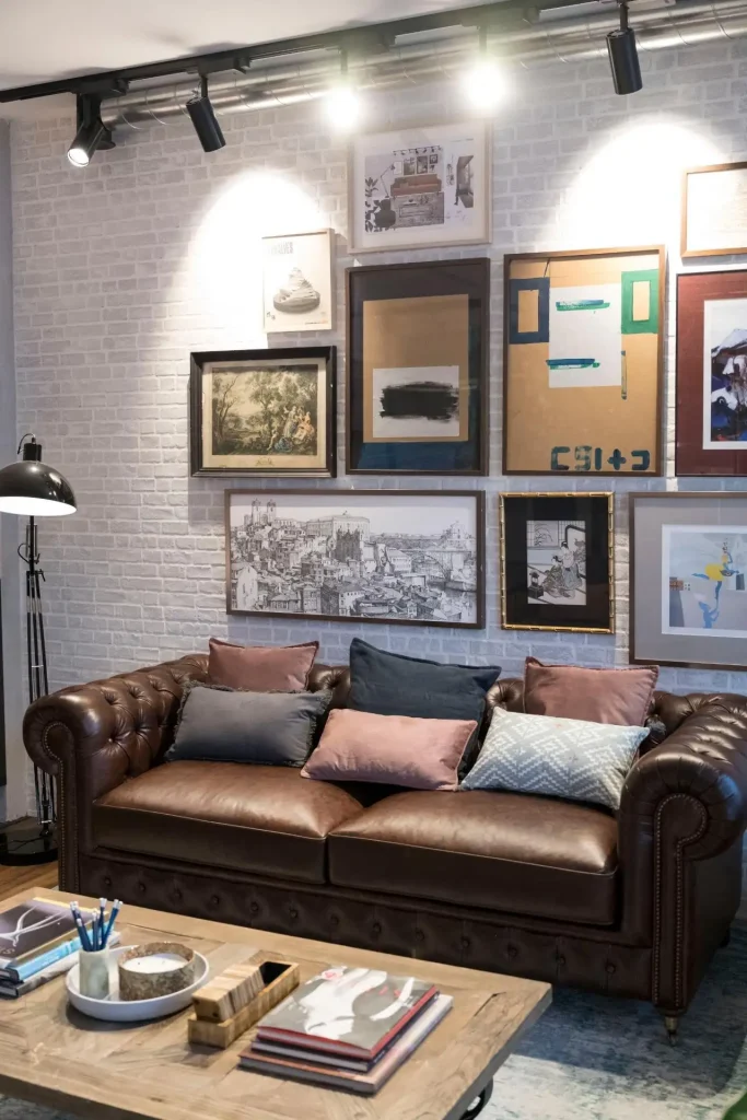 Área lounge com sofá de cabedal e parede de galeria