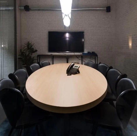 Mesa oval e televisão da sala de reuniões